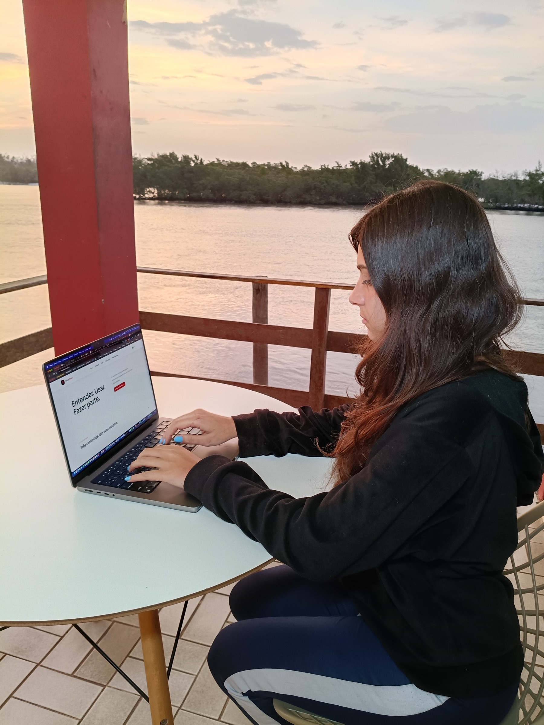 Woman studying LiberPass on a laptop by the water.